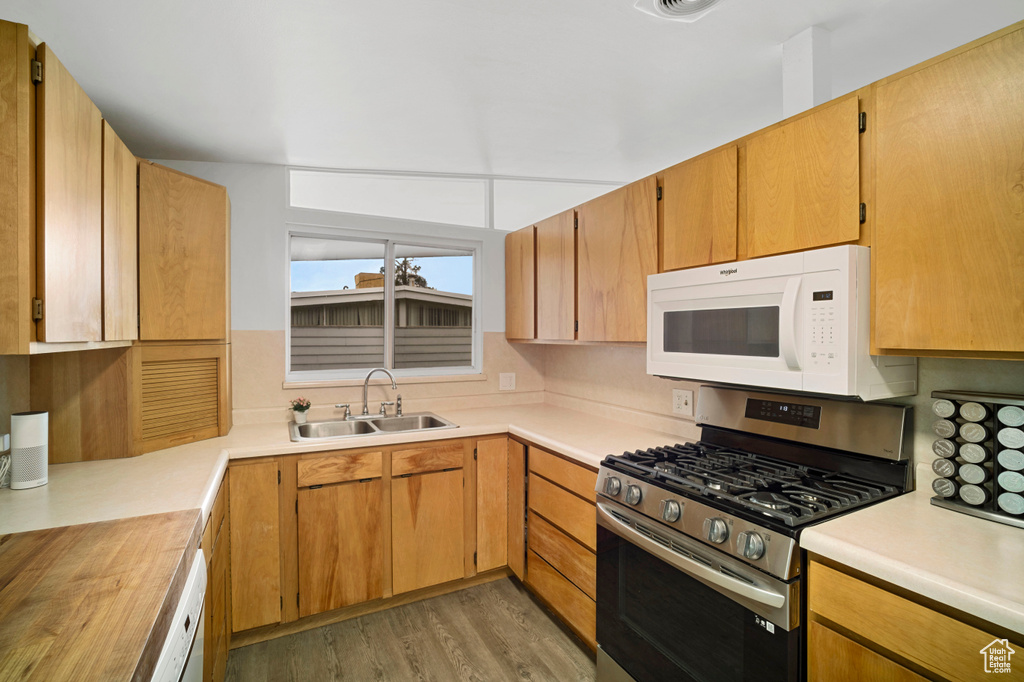 Kitchen with sink, stainless steel range with gas stovetop, and light hardwood / wood-style floors