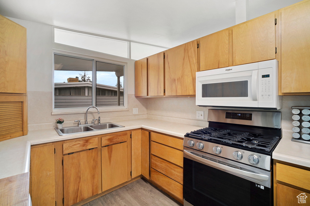 Kitchen featuring sink, light hardwood / wood-style flooring, and stainless steel range with gas stovetop