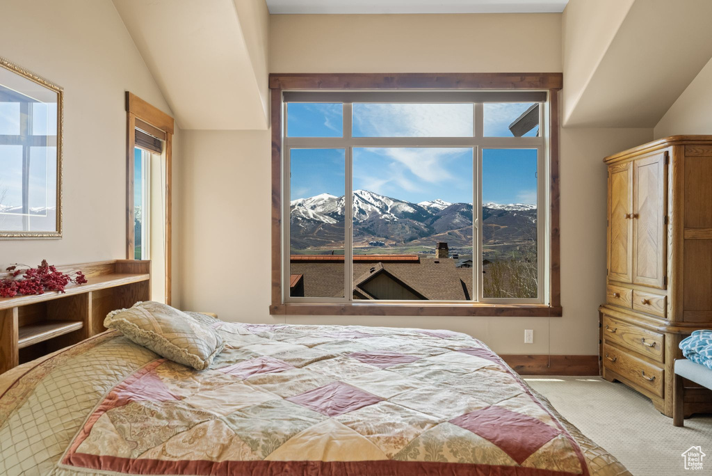 Bedroom with light colored carpet and a mountain view