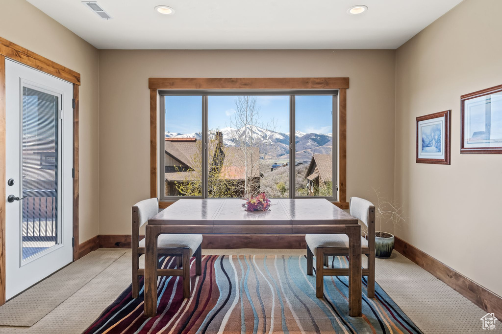 Carpeted dining area with a mountain view