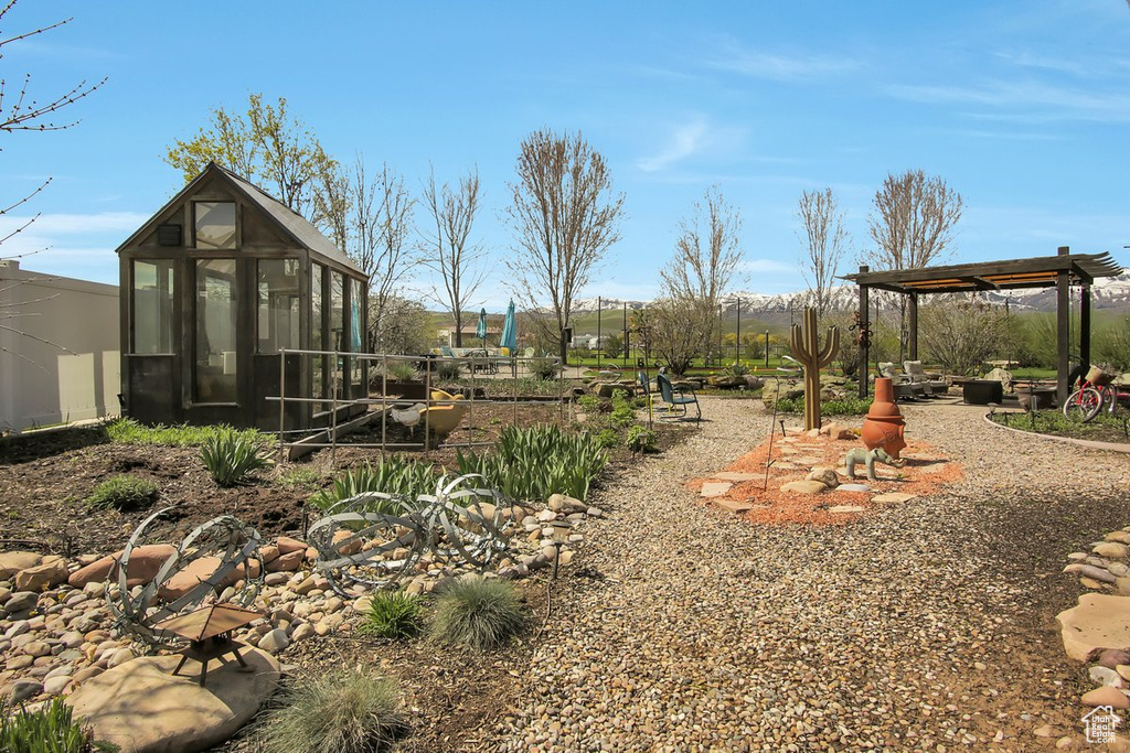 View of yard featuring a sunroom and a pergola