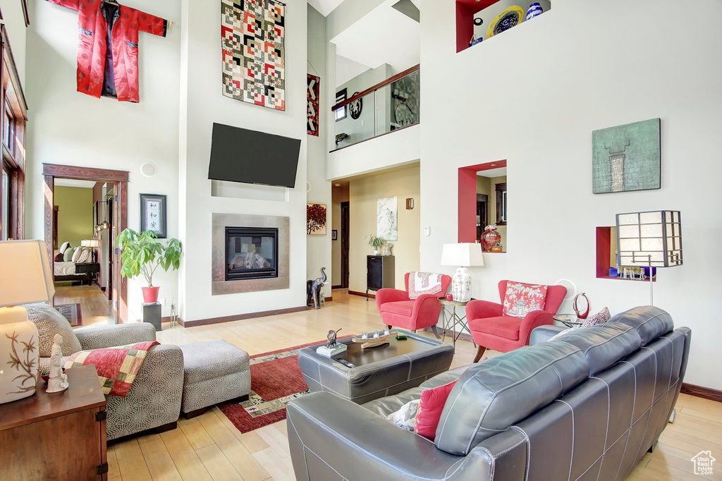 Living room with hardwood / wood-style flooring and a high ceiling