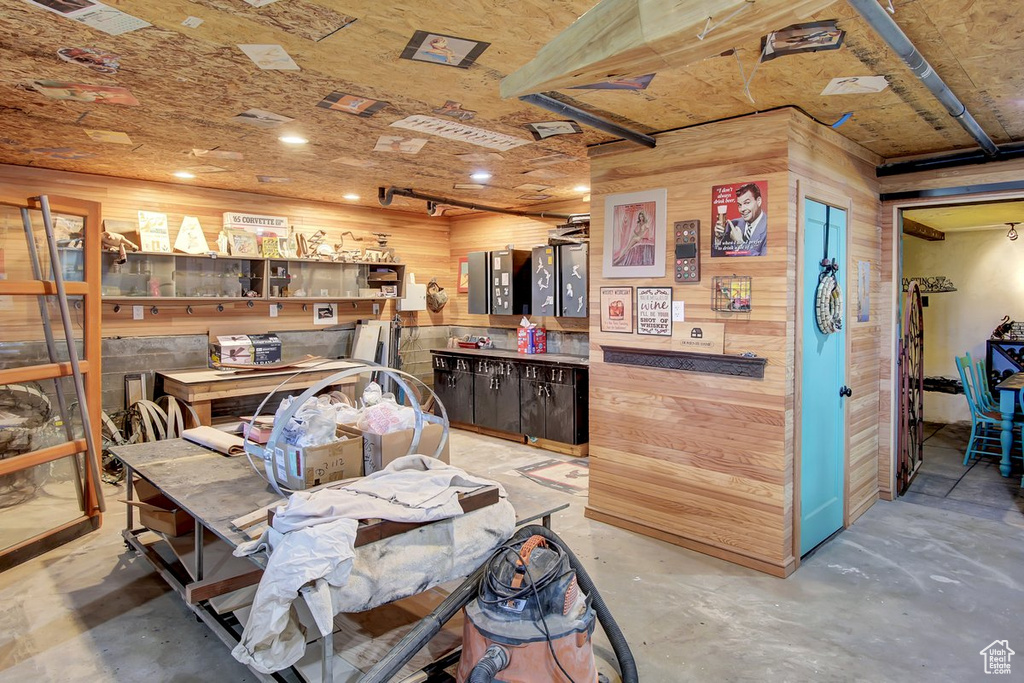 Miscellaneous room featuring wood walls and a workshop area