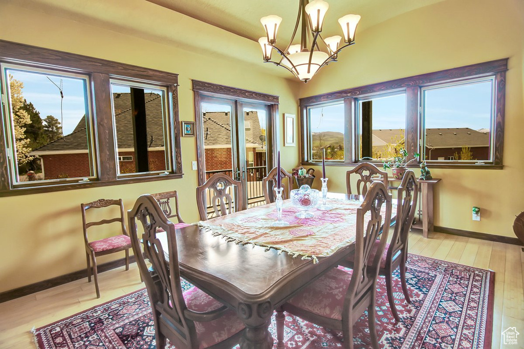 Dining space with a chandelier and wood-type flooring