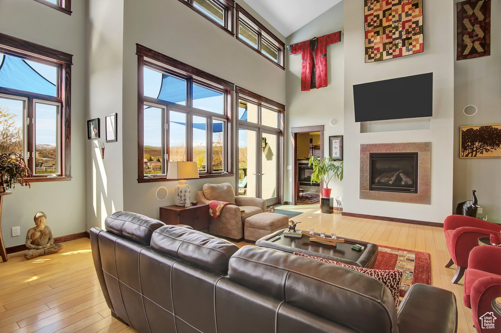 Living room with a towering ceiling and hardwood / wood-style flooring