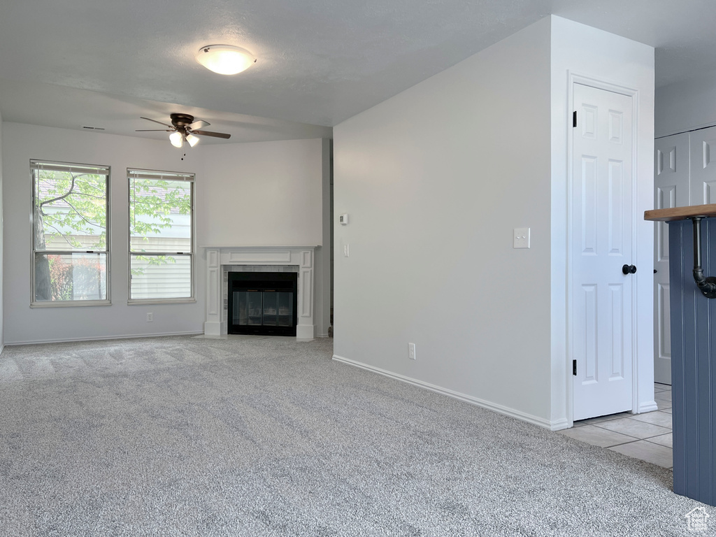 Unfurnished living room featuring light colored carpet and ceiling fan