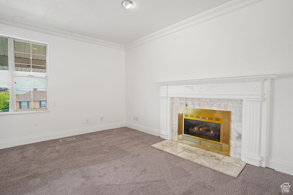 Unfurnished living room with carpet, crown molding, and a high end fireplace