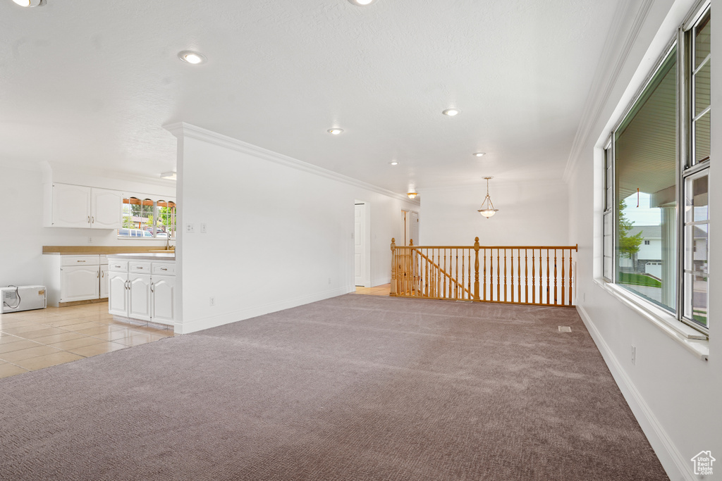 Interior space featuring crown molding, light tile floors, and a wealth of natural light