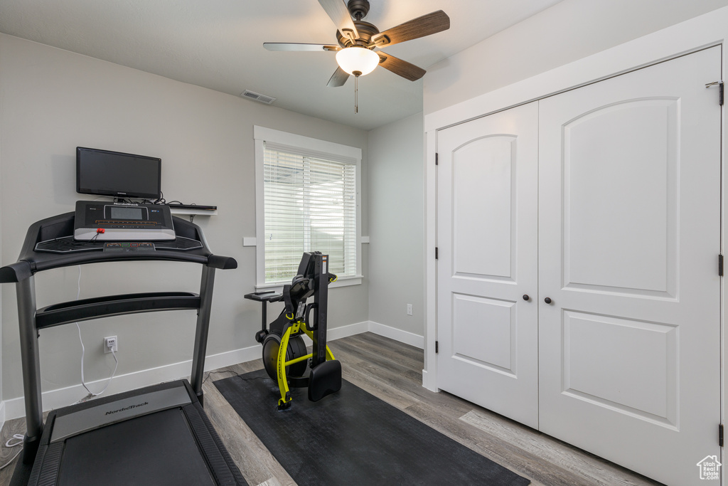 Workout room with hardwood / wood-style floors and ceiling fan