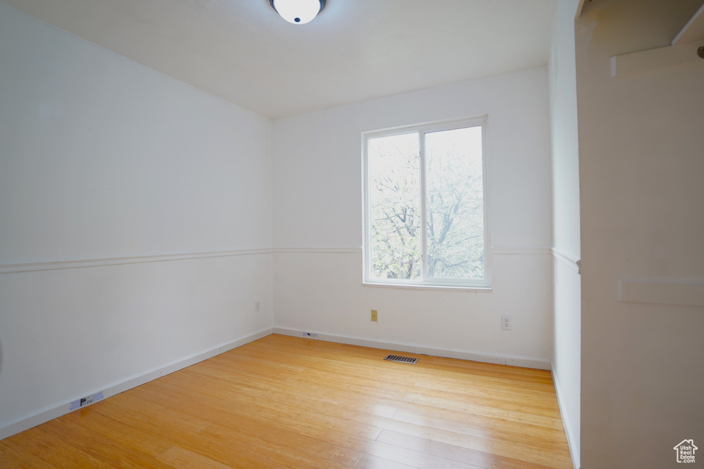 Unfurnished room with hardwood / wood-style floors and a wealth of natural light