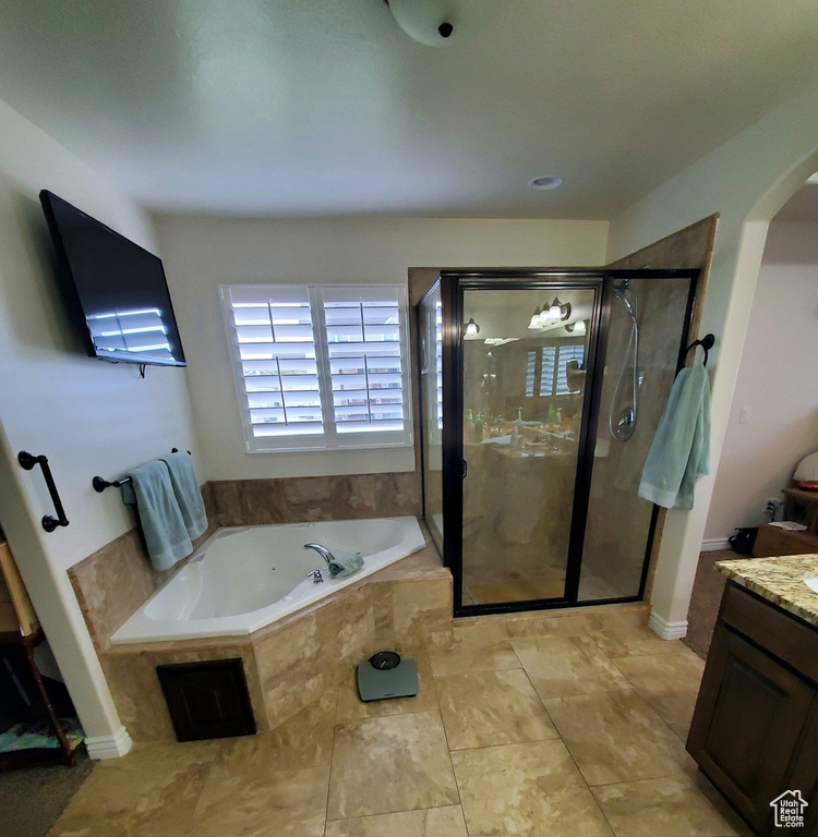 Bathroom with vanity, shower with separate bathtub, and tile floors