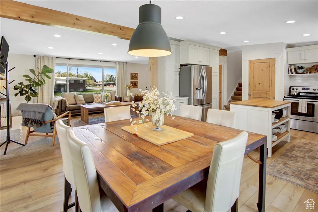 Dining area featuring light hardwood / wood-style flooring and beamed ceiling