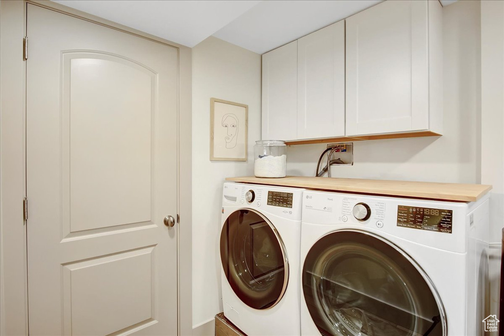 Washroom featuring cabinets, washer hookup, and separate washer and dryer