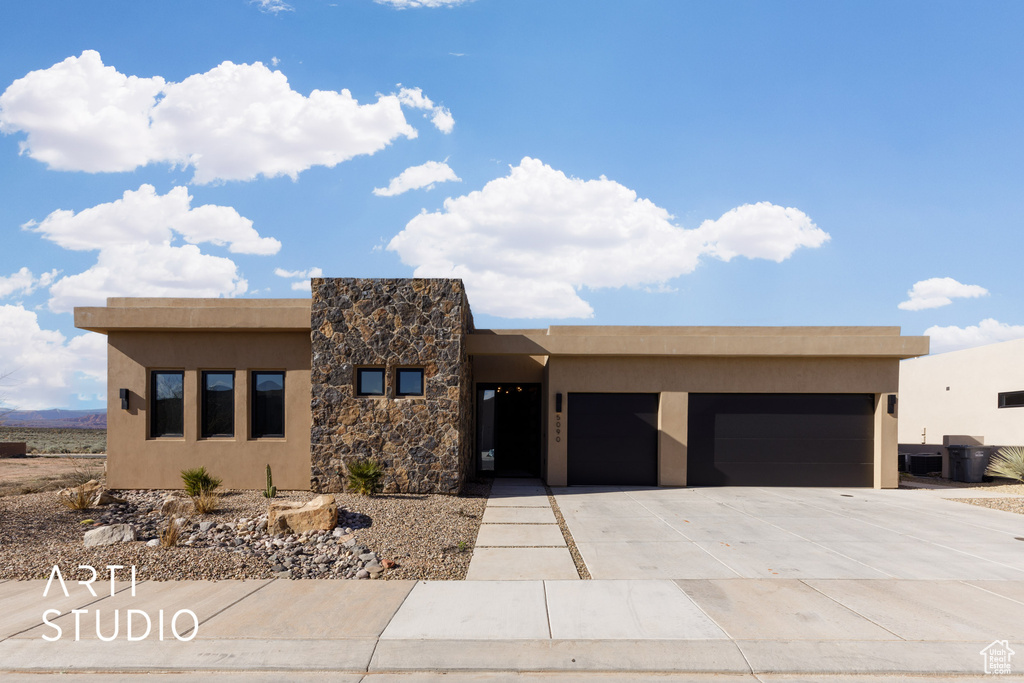 Pueblo revival-style home featuring a garage