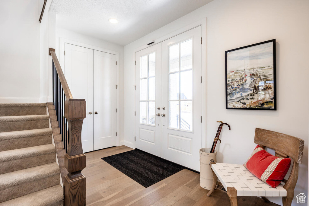 Foyer featuring a healthy amount of sunlight, hardwood / wood-style floors, and french doors