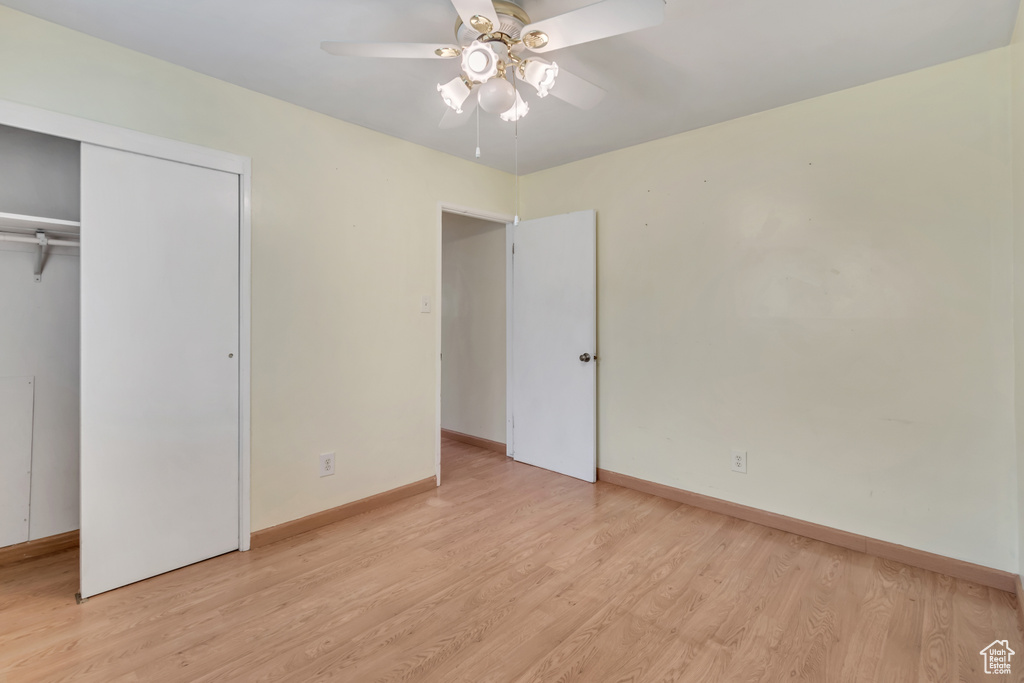 Unfurnished bedroom featuring a closet, light hardwood / wood-style floors, and ceiling fan