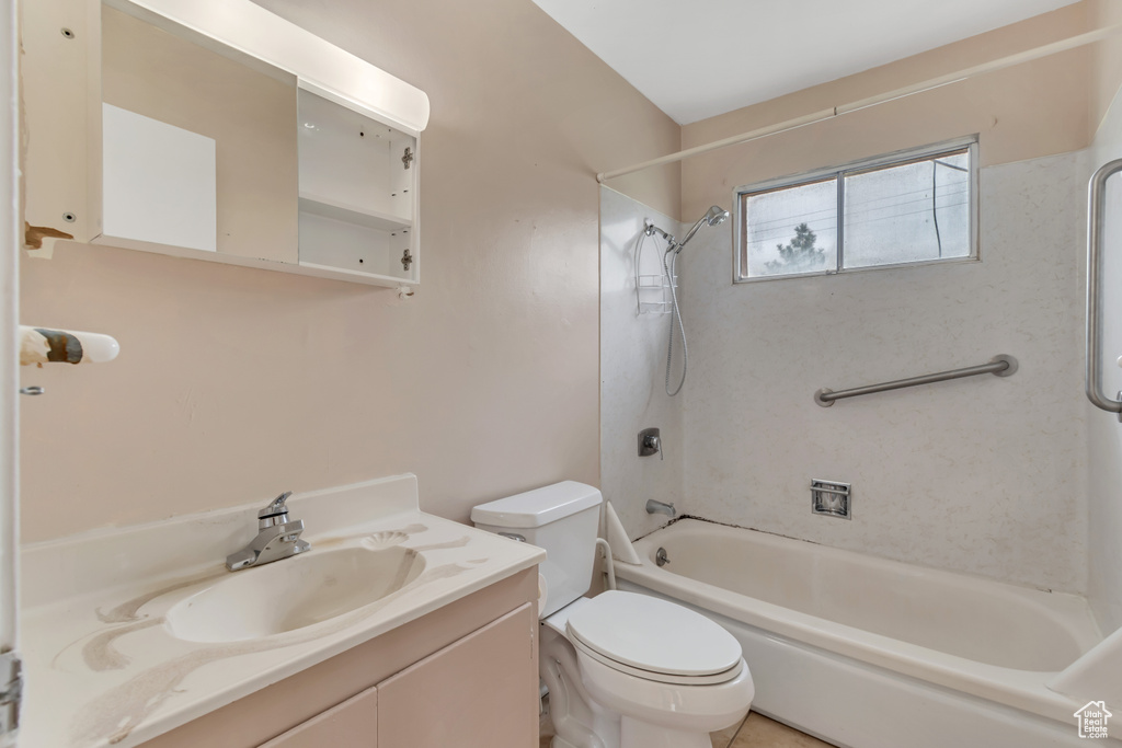 Full bathroom featuring vanity, toilet, and tiled shower / bath combo