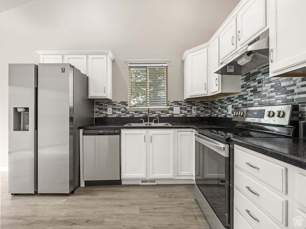 Kitchen featuring light hardwood / wood-style floors, stainless steel appliances, white cabinets, and sink