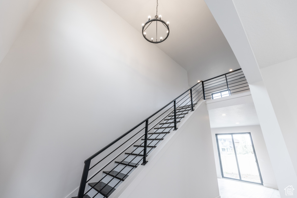 Stairway featuring an inviting chandelier and a high ceiling