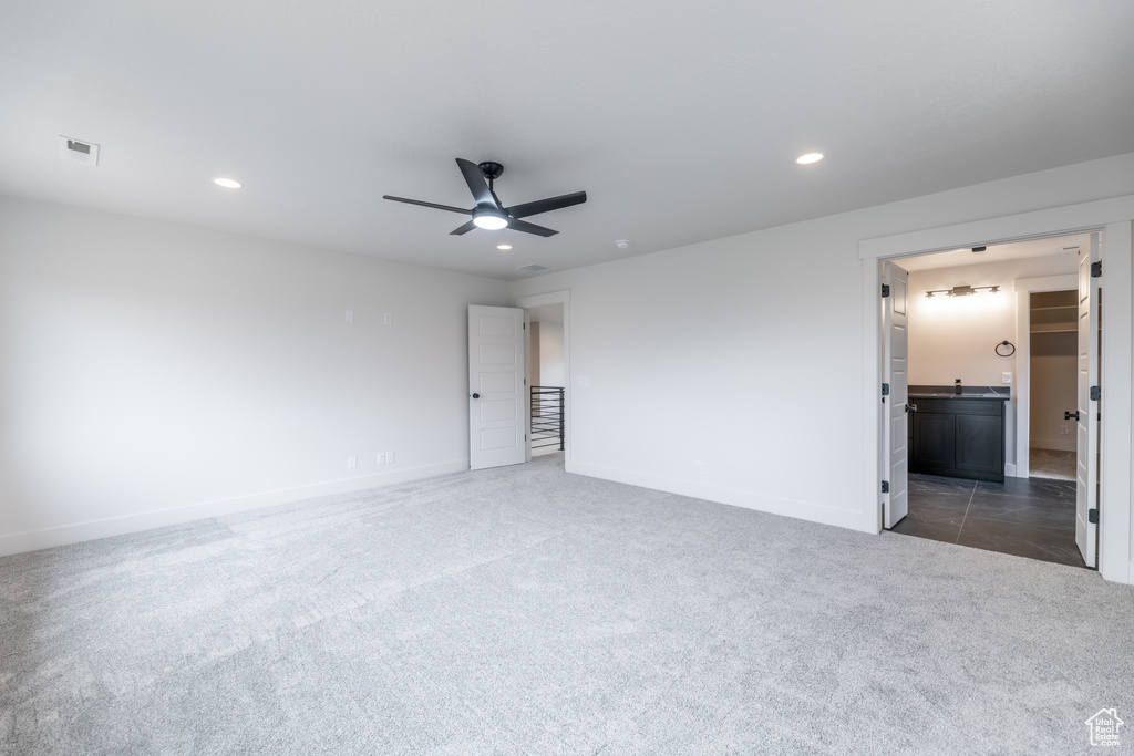 Unfurnished room with dark colored carpet and ceiling fan