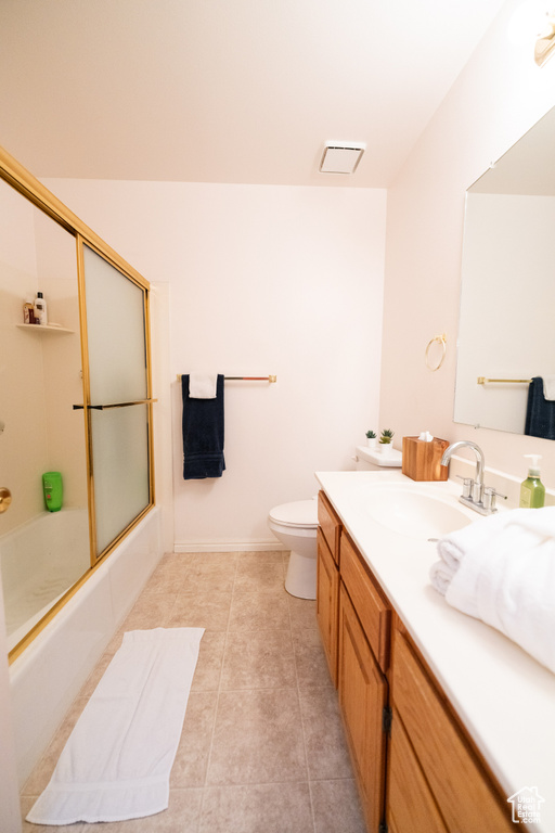 Full bathroom with vanity, tile floors, toilet, and enclosed tub / shower combo