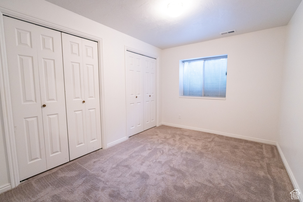 Unfurnished bedroom with multiple closets and carpet flooring