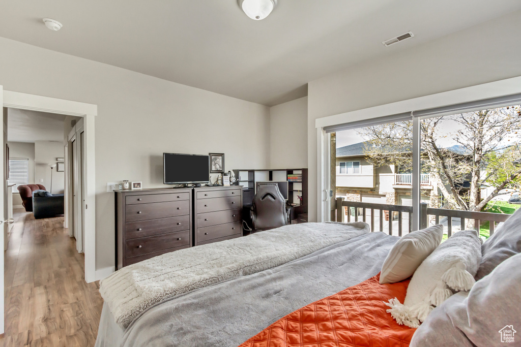 Bedroom featuring light hardwood / wood-style flooring, access to exterior, and multiple windows