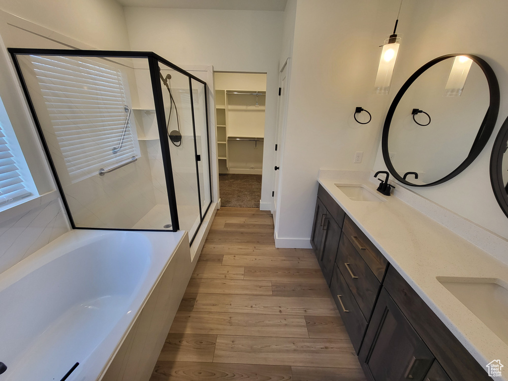 Bathroom featuring dual bowl vanity, independent shower and bath, and hardwood / wood-style floors