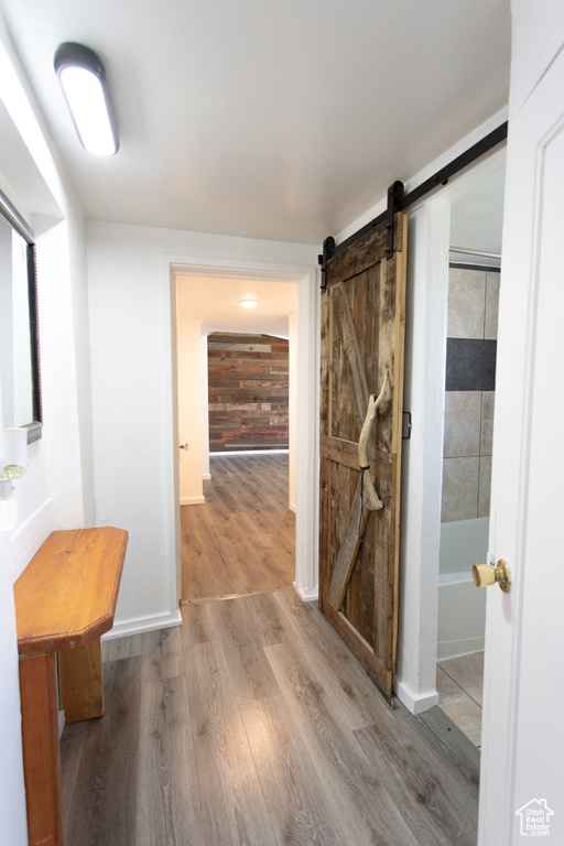 Hallway with hardwood / wood-style floors and a barn door