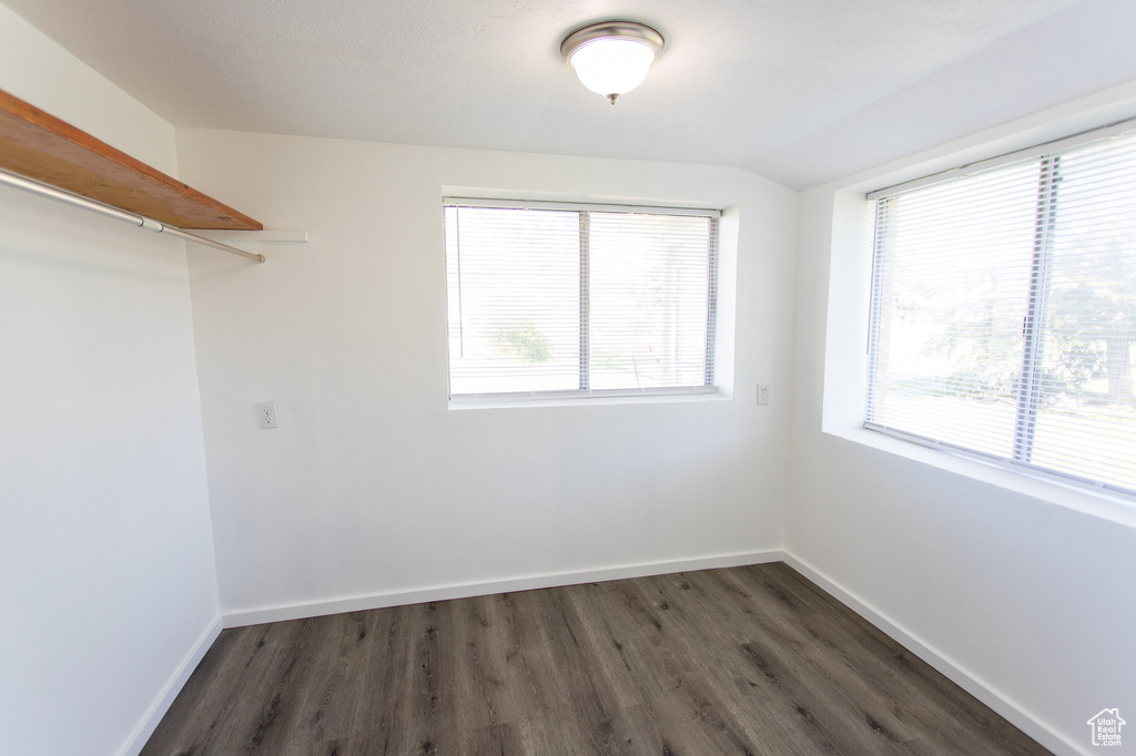 Spare room with a wealth of natural light and dark hardwood / wood-style flooring