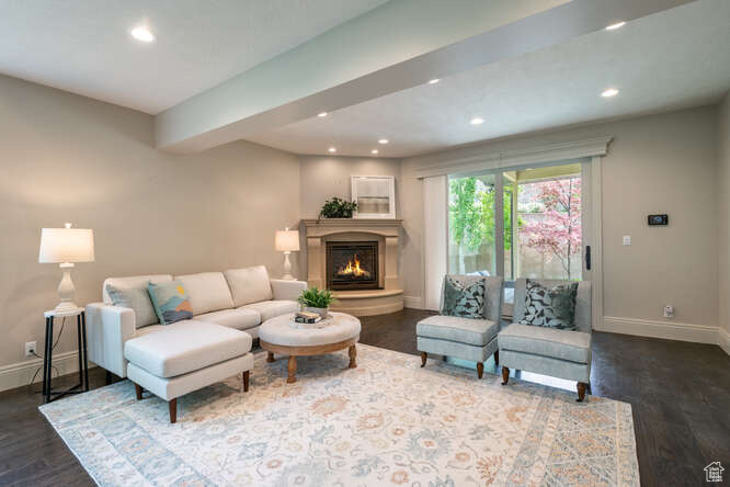 Living room featuring dark hardwood / wood-style flooring and beamed ceiling