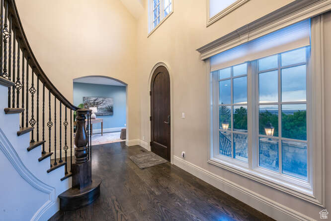 Entryway featuring a towering ceiling and dark hardwood / wood-style flooring