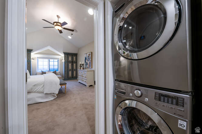 Washroom featuring carpet flooring, ceiling fan, and stacked washer / drying machine