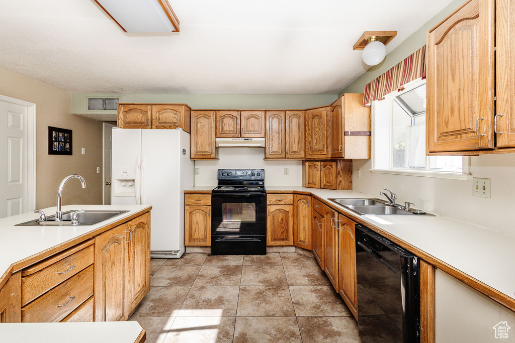 Kitchen featuring sink, light tile floors, and black appliances