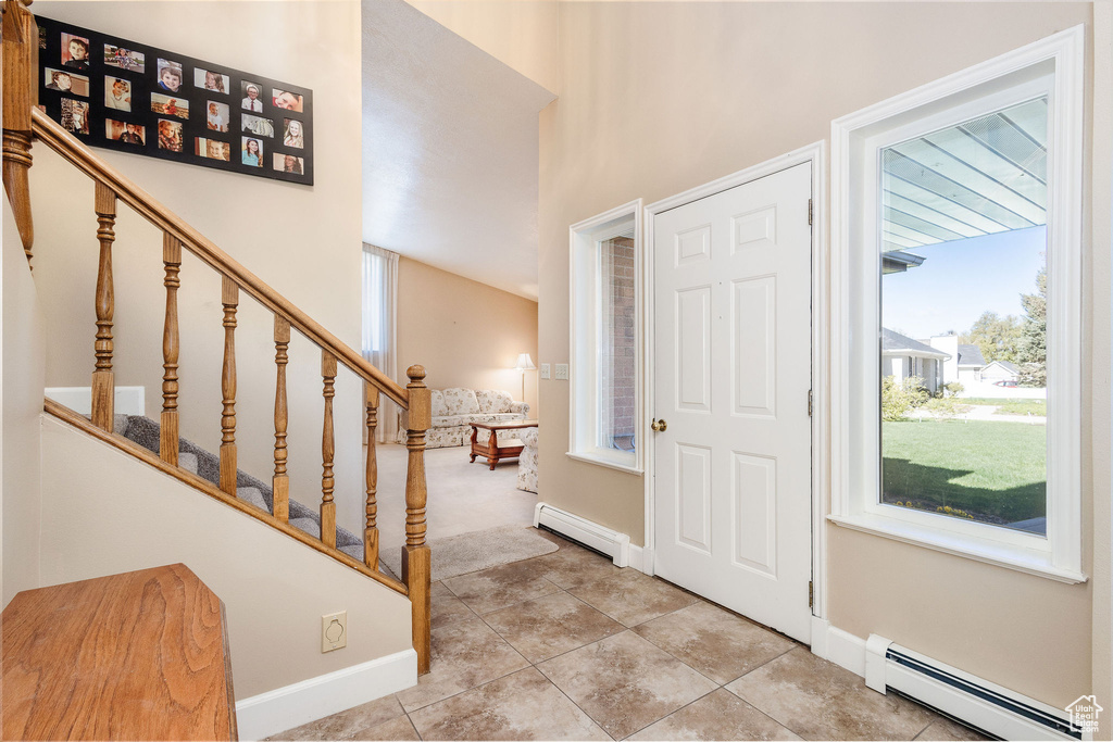 Entrance foyer featuring a baseboard heating unit and light tile floors