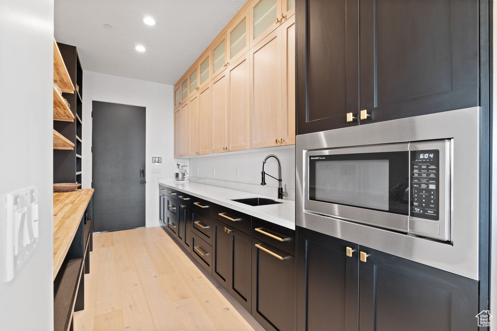 Kitchen featuring light hardwood / wood-style floors, stainless steel microwave, and sink