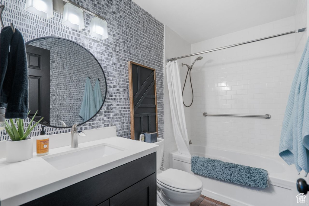 Full bathroom featuring tile walls, shower / tub combo, toilet, and vanity