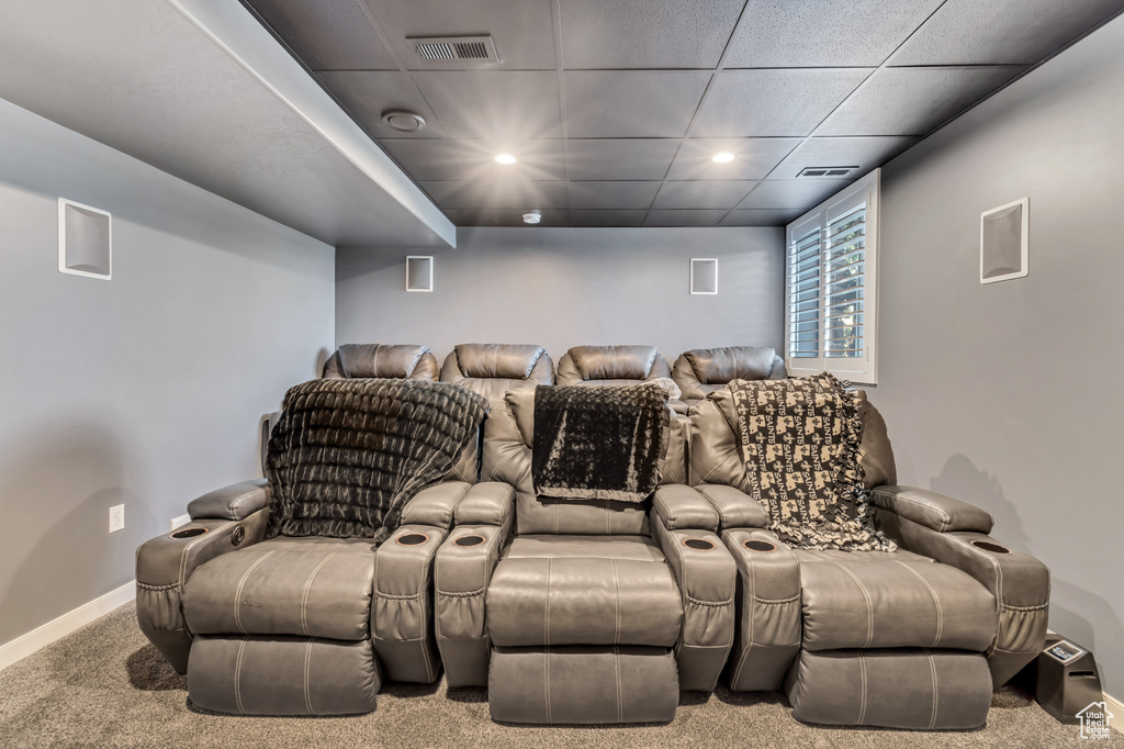 Carpeted home theater with a paneled ceiling