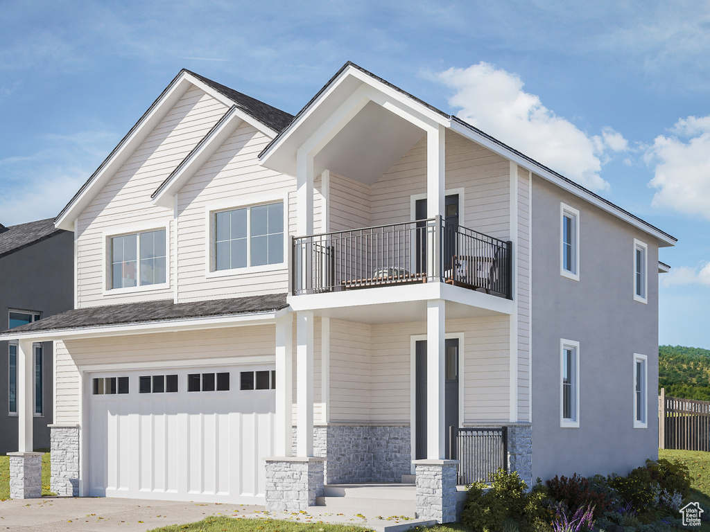 View of front facade featuring a front yard, a garage, and a balcony