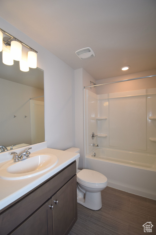 Full bathroom with tile flooring, washtub / shower combination, toilet, and large vanity