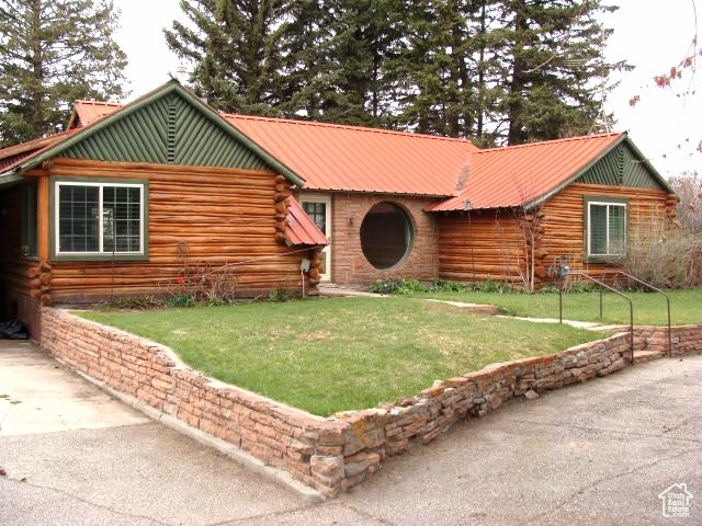 Log-style house featuring a front lawn