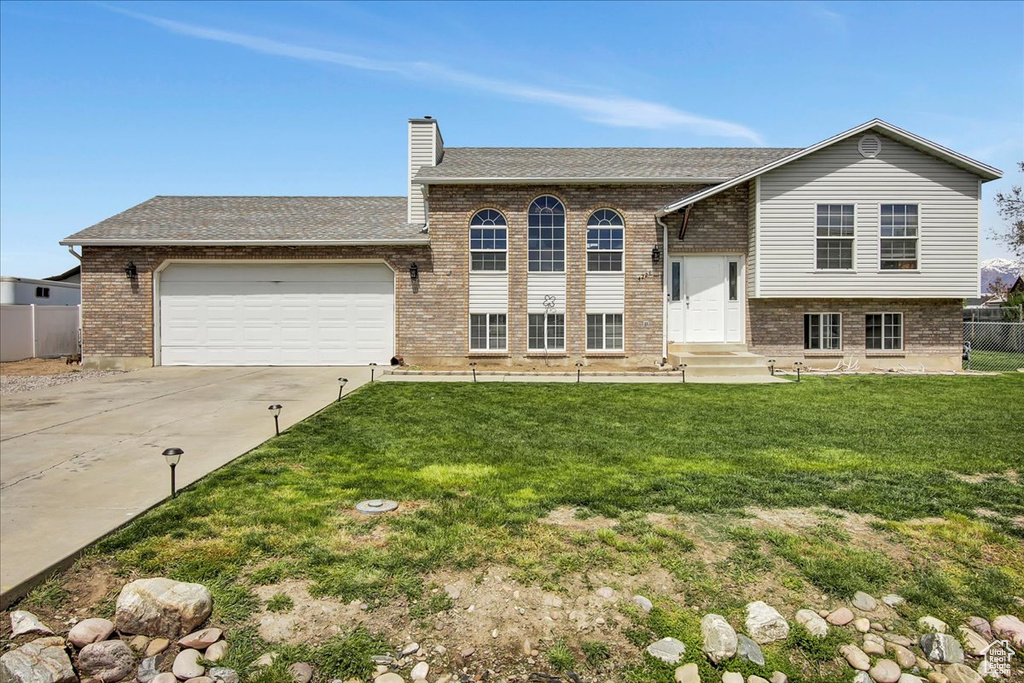 View of front of home with a garage and a front yard