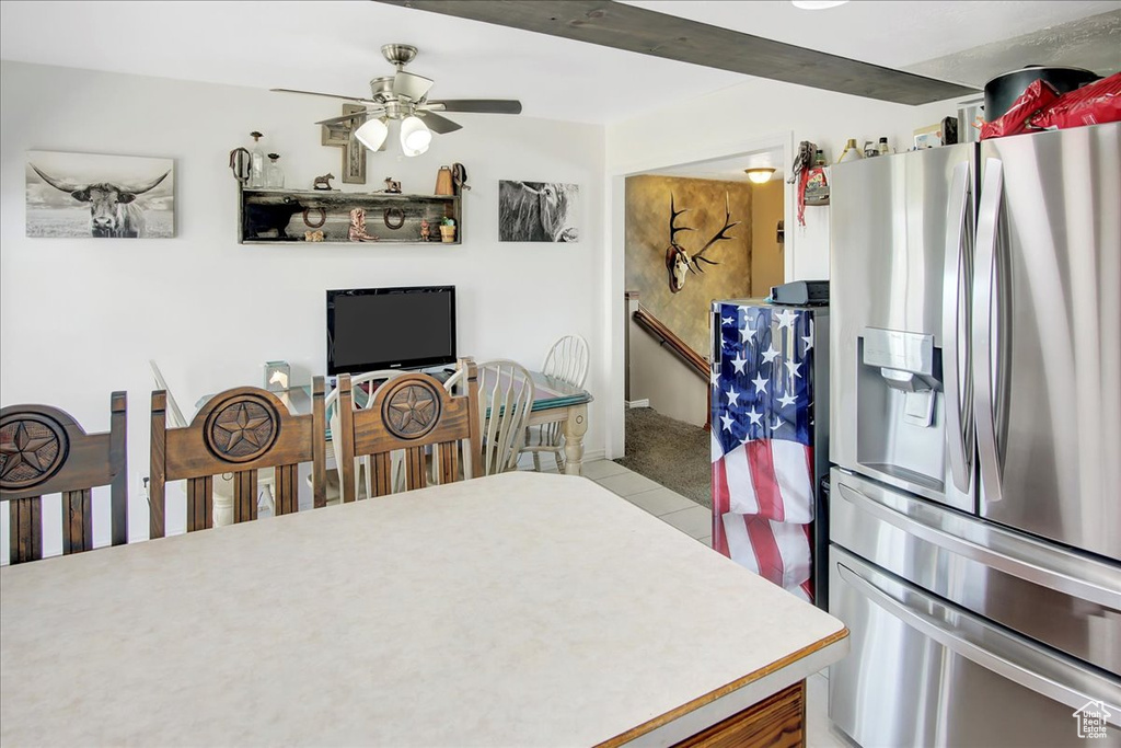 Kitchen featuring ceiling fan, stainless steel fridge, and light tile floors