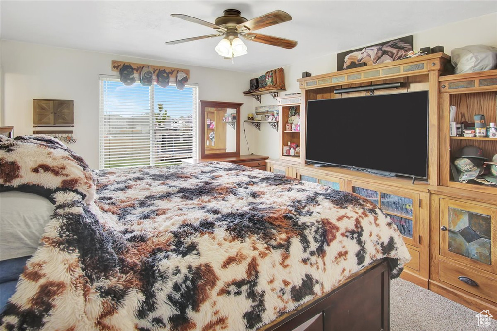 Carpeted bedroom featuring ceiling fan