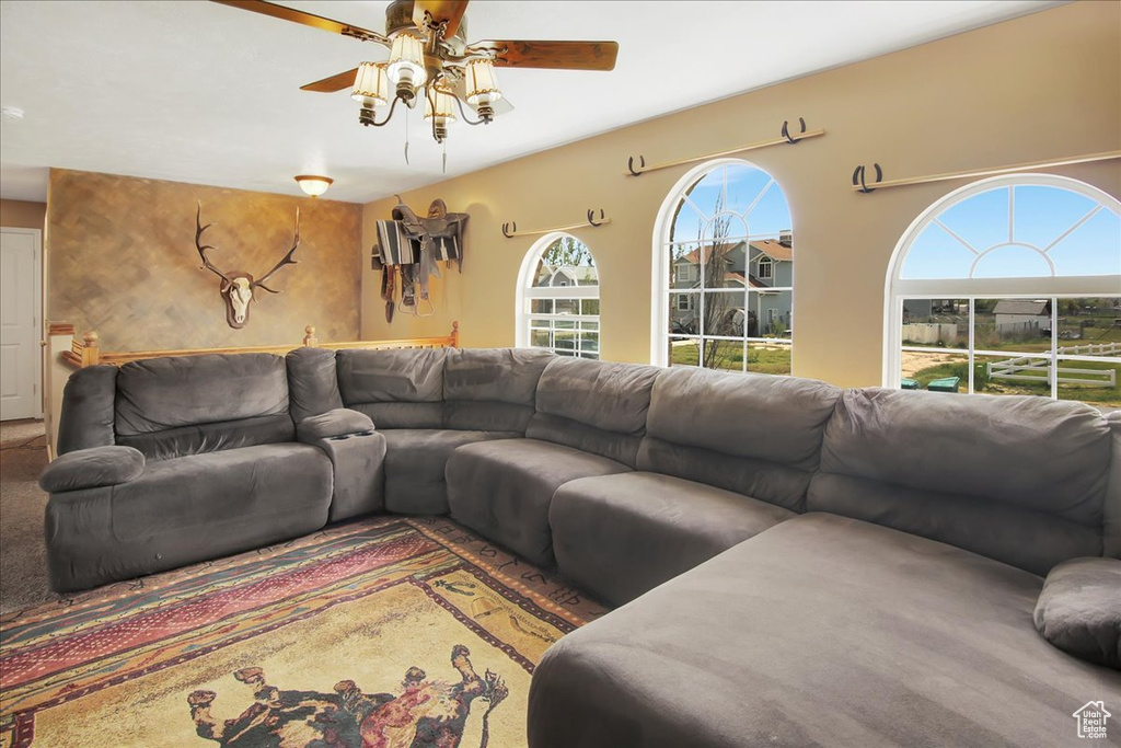 Carpeted living room featuring ceiling fan