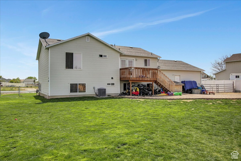 Rear view of property with a deck, a yard, and central air condition unit