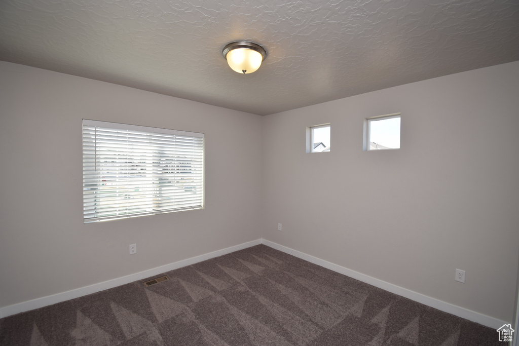 Spare room with a textured ceiling and carpet flooring