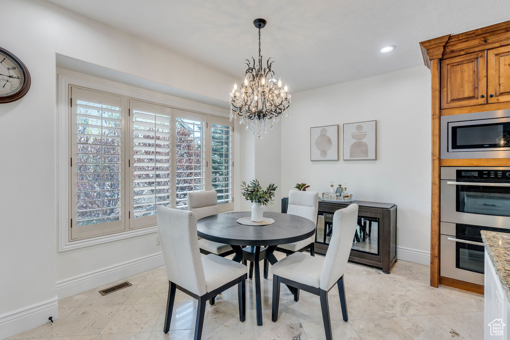Dining area with an inviting chandelier and light tile floors