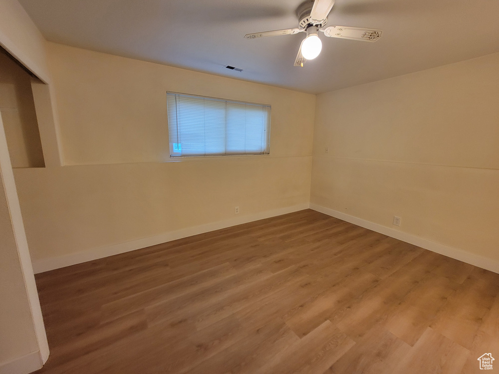 Spare room with wood-type flooring and ceiling fan