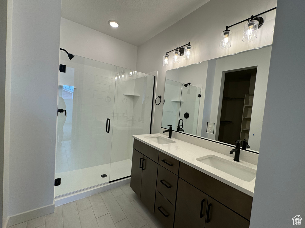 Bathroom featuring walk in shower, double vanity, and tile flooring